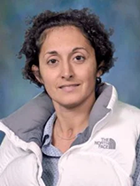 An image of Dr. Jitka Virag. She has pale skin, curly black hair, and is wearing a white North Face jacket.